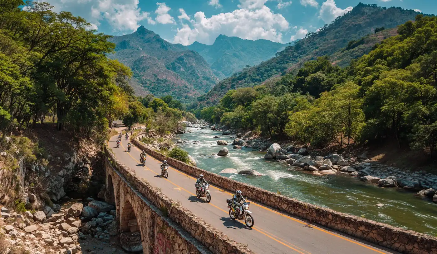 Riders on a stone bridge road along a turquoise river and mountains