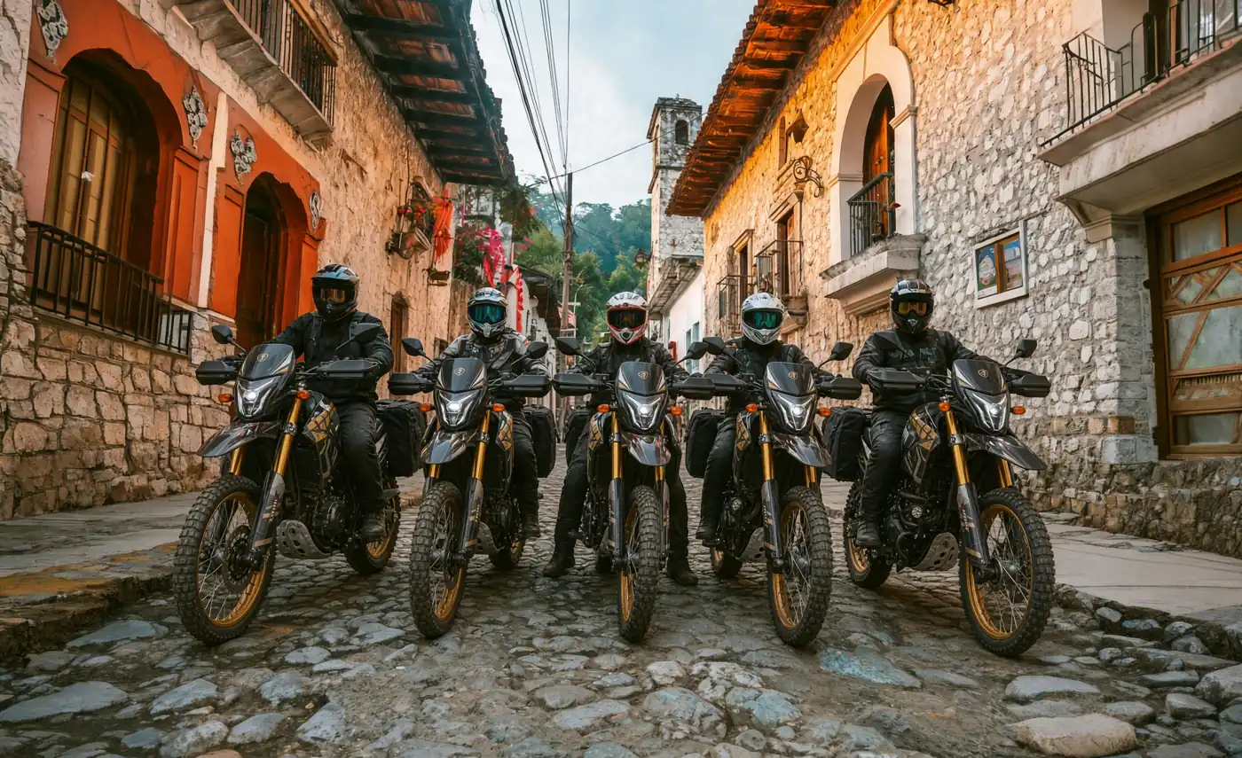 Five dirt bike riders on a cobblestone street between colonial stone houses